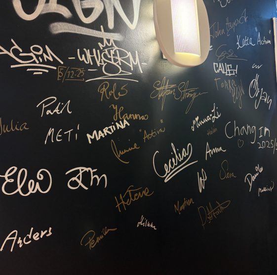 En svart vägg med signaturer.