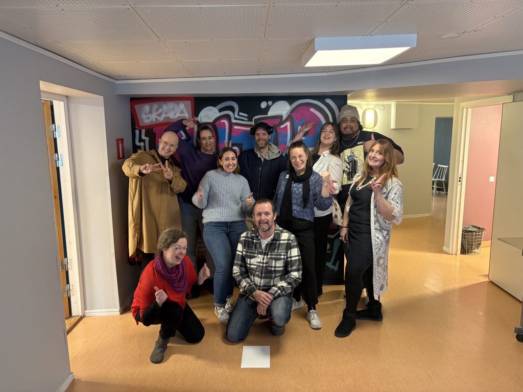 Gruppfoto framför en vägg inomhus.